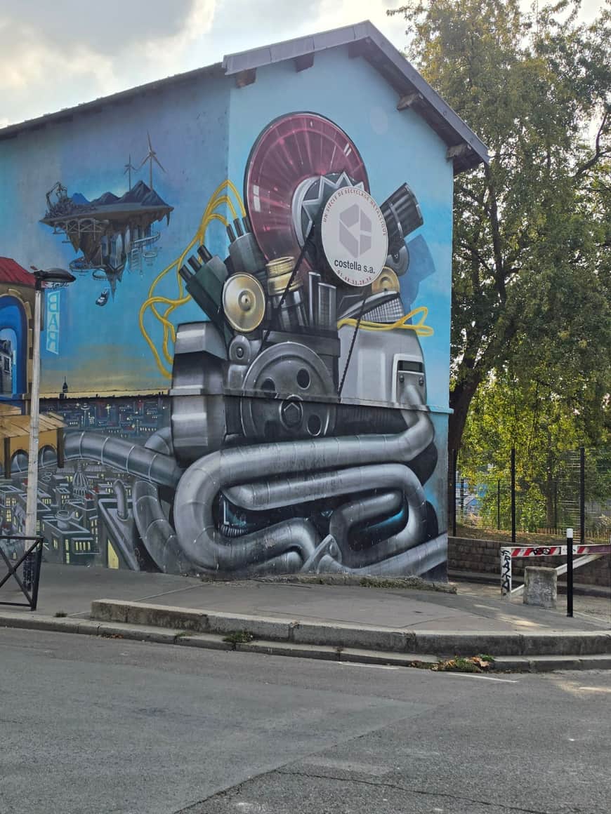 Grande fresque industrielle de machines et de métaux sur une façade bleue
