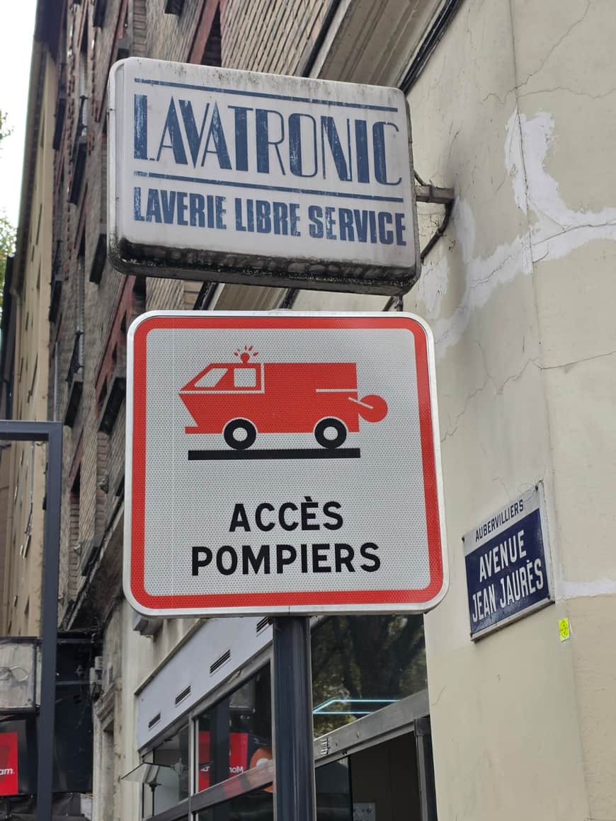 Enseigne Lavatronic, panneau Accès pompiers et plaque Avenue Jean-Jaurès à Aubervilliers