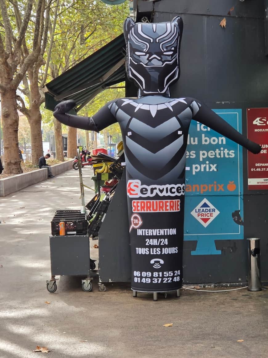 Personnage publicitaire gonflable inspiré de Black Panther devant un commerce de serrurerie