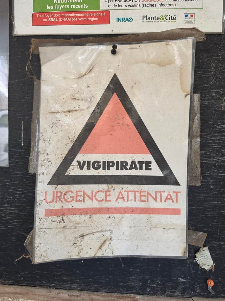Affiche Vigipirate Urgence attentat fixée sur un panneau dans le cimetière