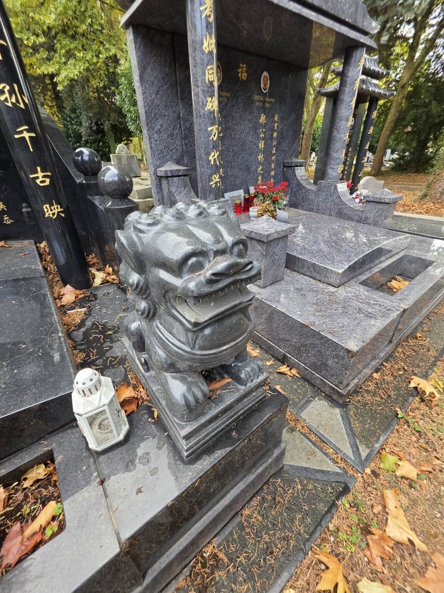 Lion gardien sculpté devant un monument funéraire chinois en pierre noire