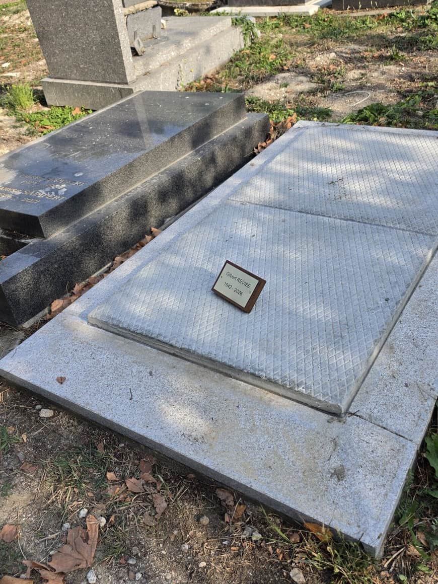 Petite plaque portant le nom Gilbert Previse et les dates 1942–2026, posée sur une dalle funéraire claire non gravée