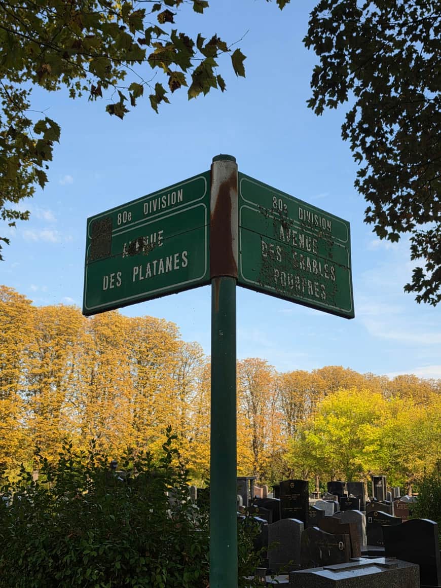 Panneaux verts anciens indiquant les 80e et 82e divisions, l’avenue des Platanes et l’avenue des Érables rouges, au-dessus des tombes