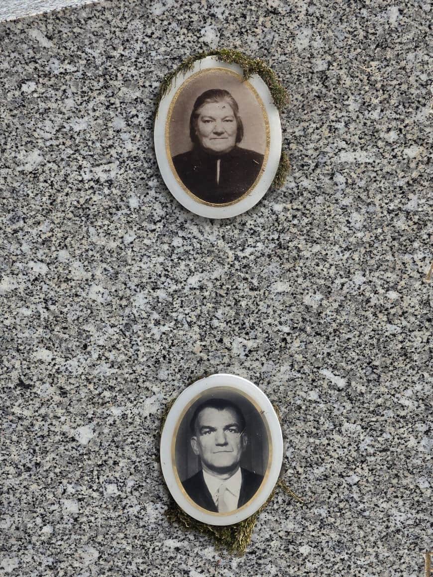 Deux portraits funéraires ovales, une femme et un homme, fixés verticalement sur une pierre claire et bordés de mousse