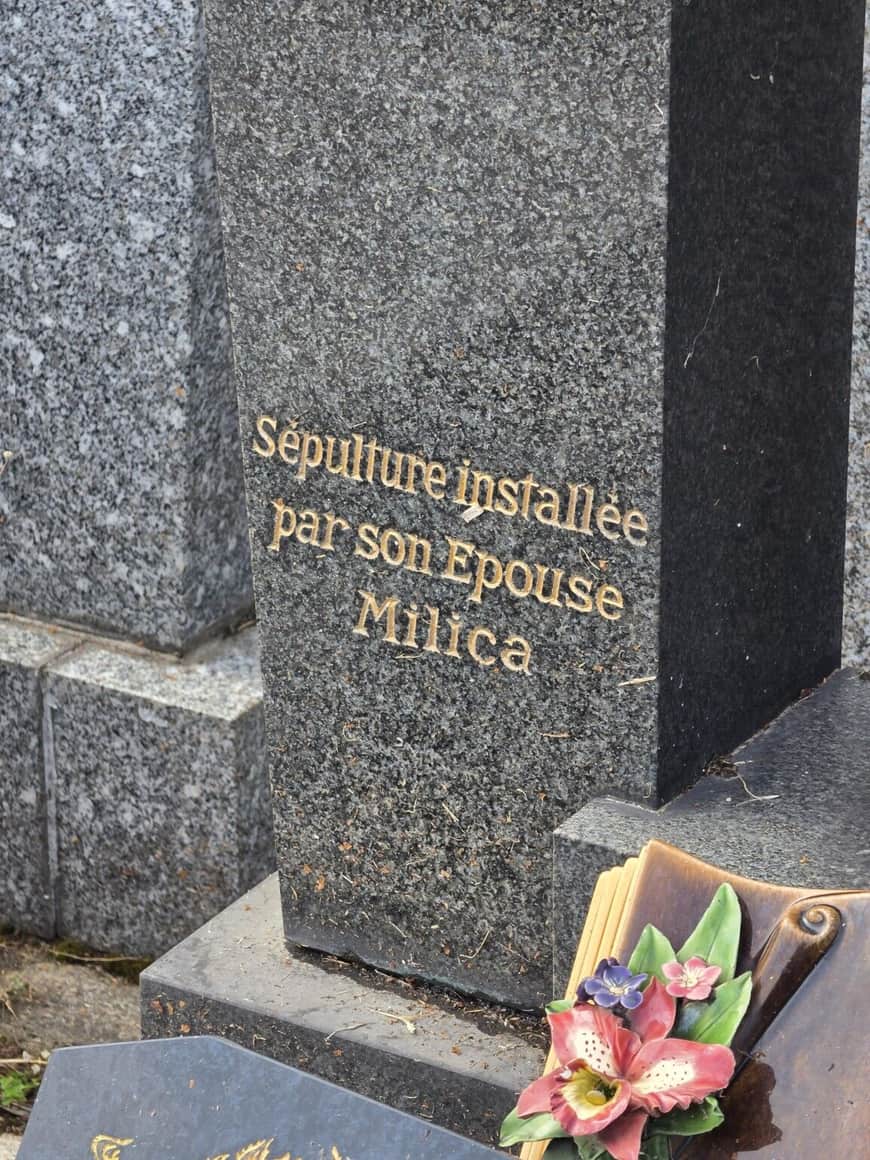Inscription dorée sur un monument noir indiquant Sépulture installée par son épouse Milica, avec fleur en céramique
