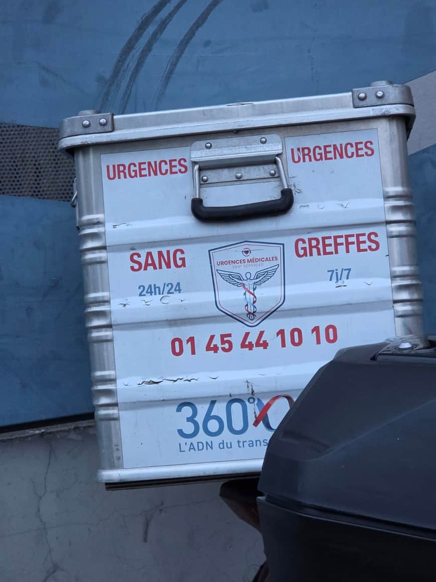 Caisse métallique fixée à un véhicule et portant les mentions Urgences, Sang 24 heures sur 24 et Greffes 7 jours sur 7