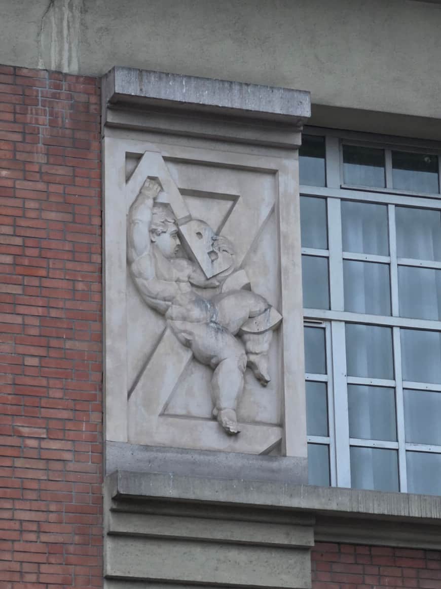 Relief de pierre représentant une figure levant un grand instrument triangulaire