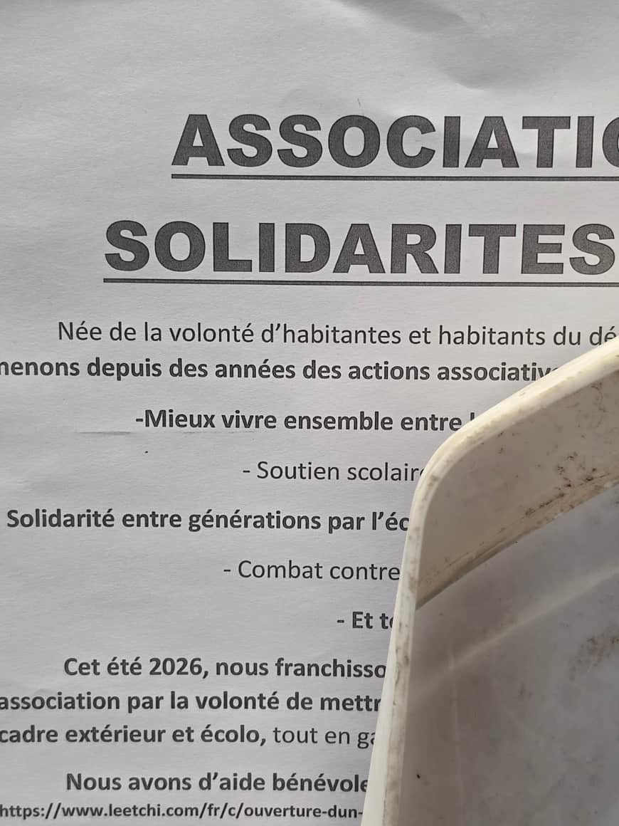 Affiche Association Solidarités partiellement masquée au premier plan