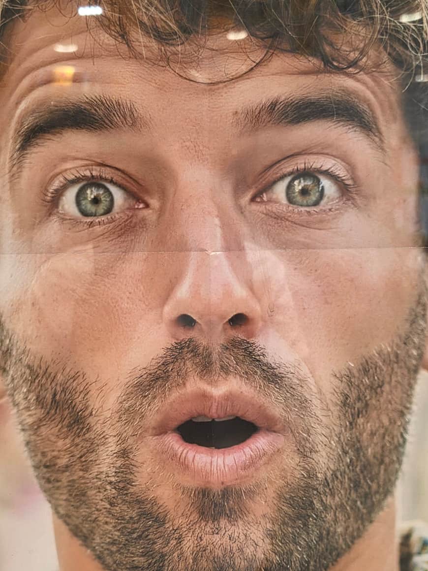 Très gros plan publicitaire sur un homme aux yeux écarquillés et à la bouche ouverte
