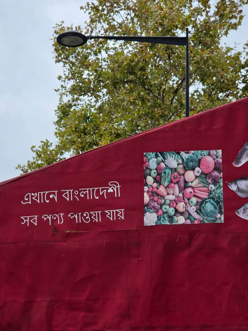 Banderole rouge en écriture bengalie annonçant des produits bangladais