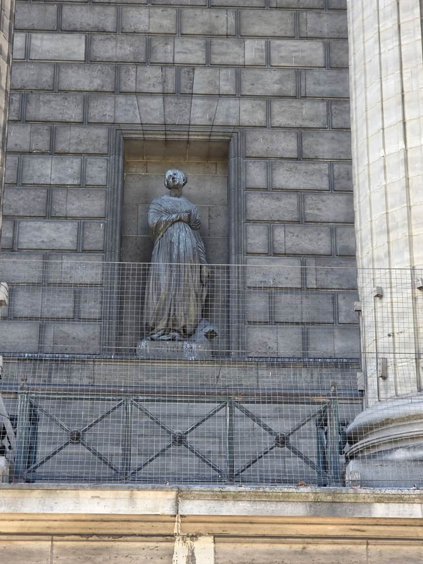 Statue de Sainte Hélène dans une niche de pierre derrière une grille