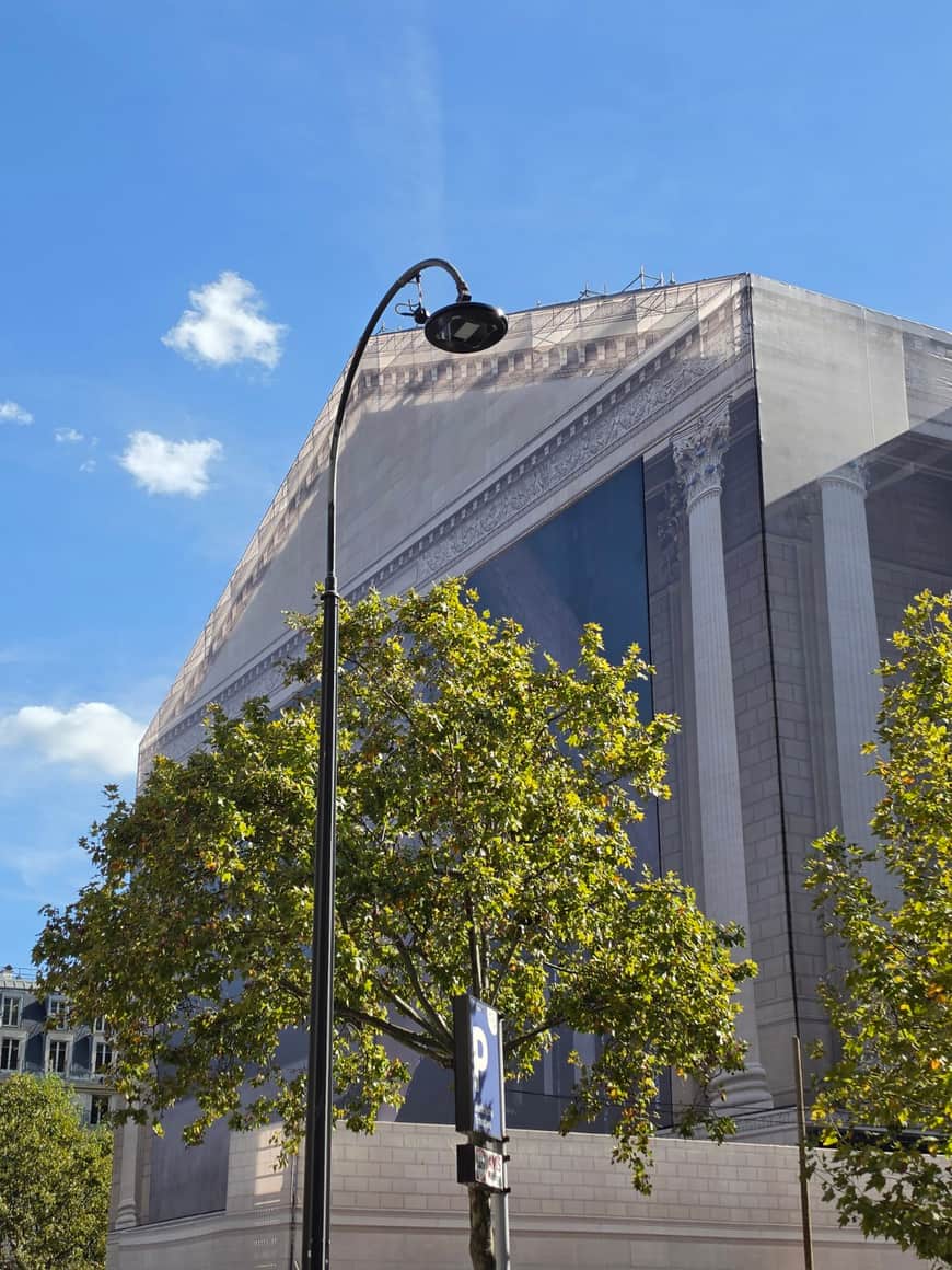 Église de la Madeleine enveloppée d’une toile de chantier imprimant son architecture