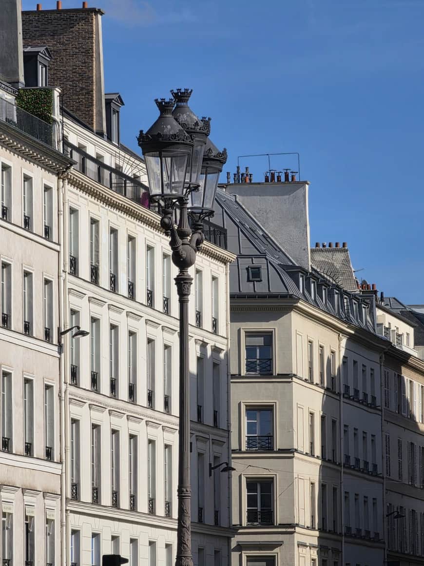 Réverbère monumental devant des façades parisiennes sous un ciel bleu