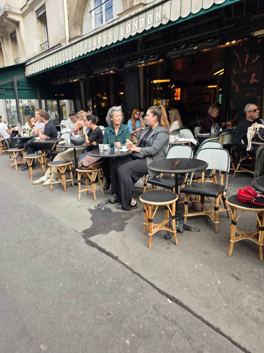 Terrasse du Café Paris London occupée par plusieurs groupes en conversation