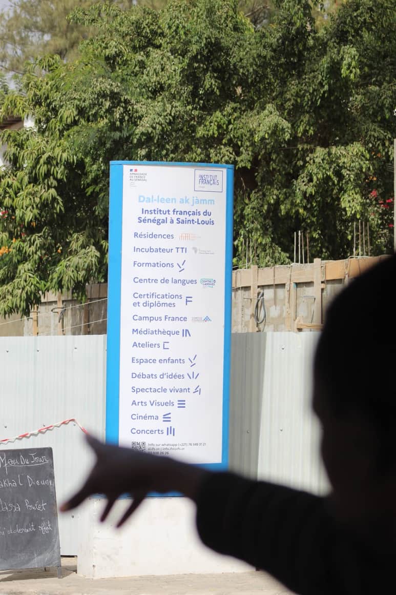 Liste affichée devant laquelle passe une main en silhouette.