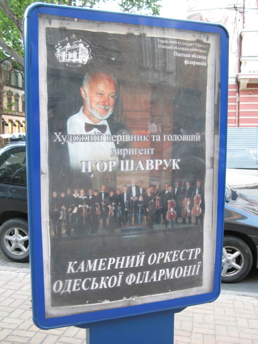 Affiche d’un chef d’orchestre derrière une vitre.