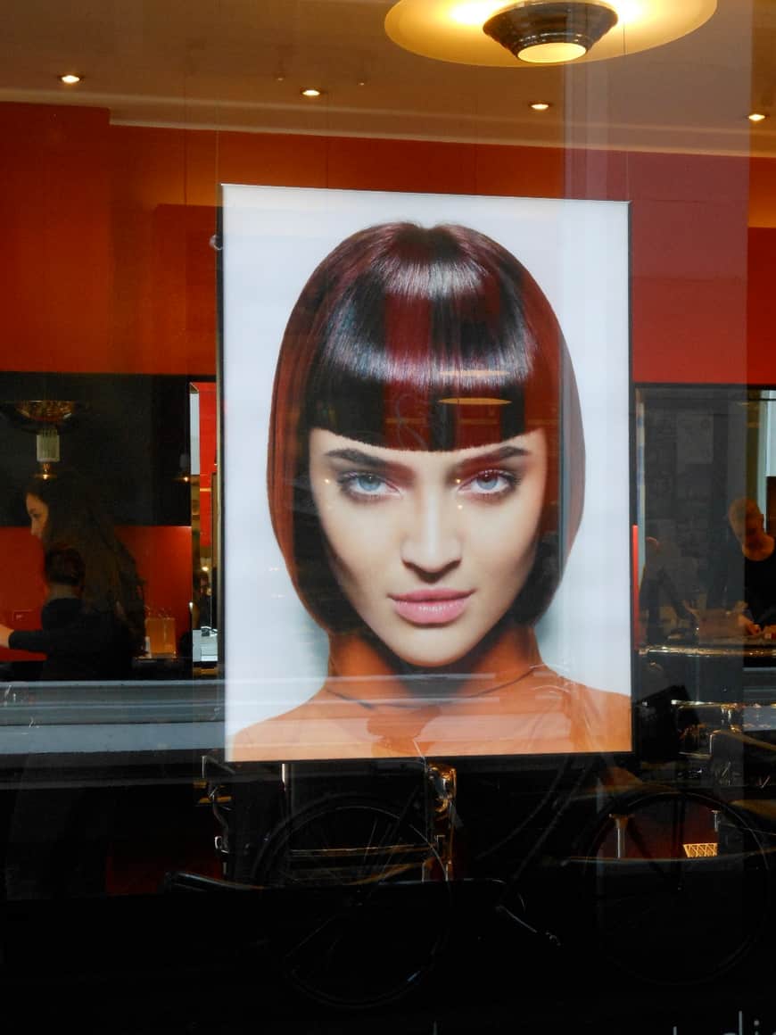Portrait de coiffure géométrique dans une vitrine.