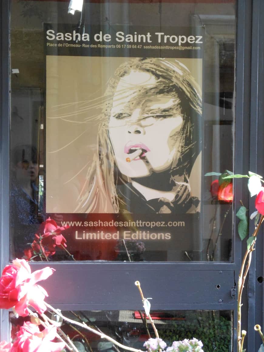 Affiche évoquant Saint-Tropez derrière une vitre.