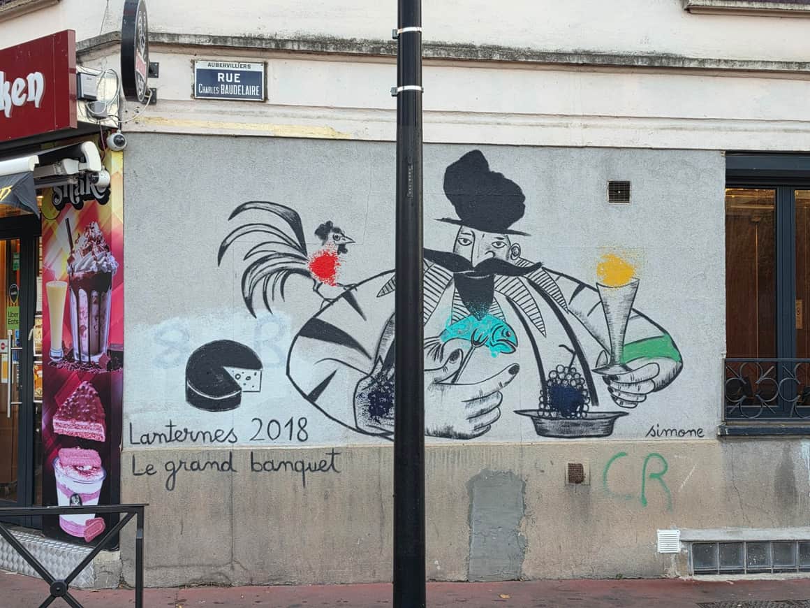 Fresque du Grand Banquet sous la plaque de la rue Charles-Baudelaire à Aubervilliers