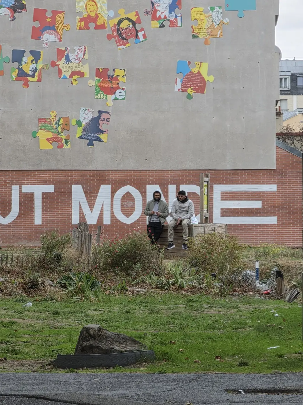 Grand panneau illustré au-dessus d’un terrain herbeux, avec une personne debout au pied du mur