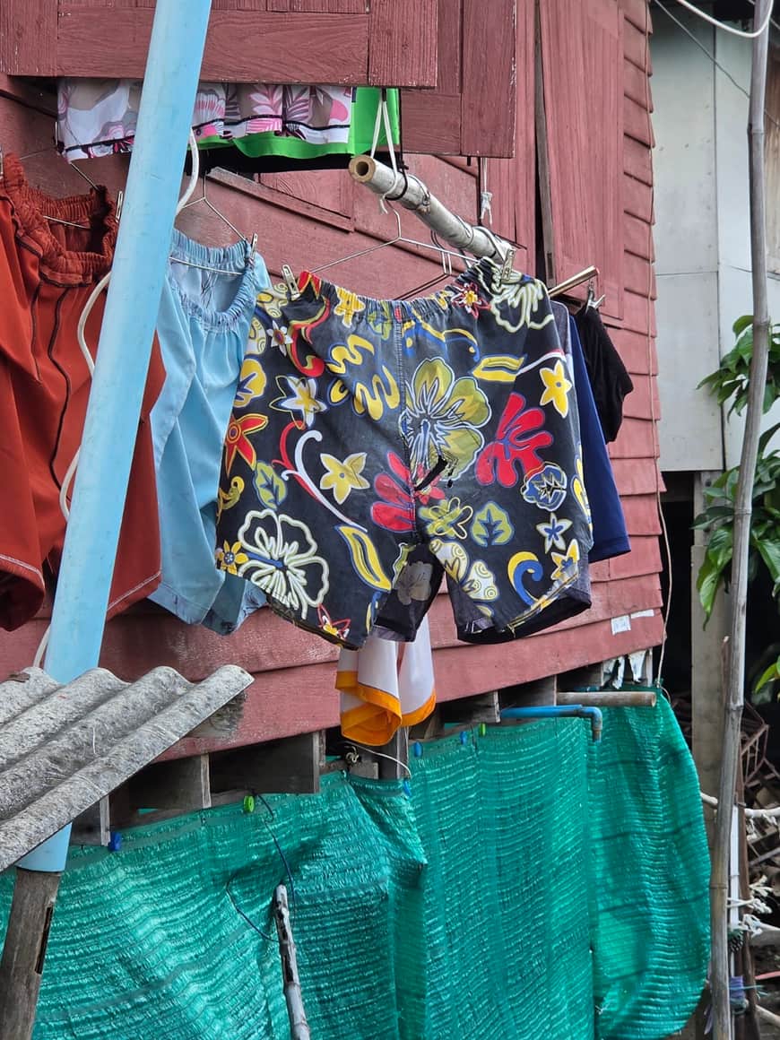 Sac ou vêtement à motifs suspendu devant une façade.