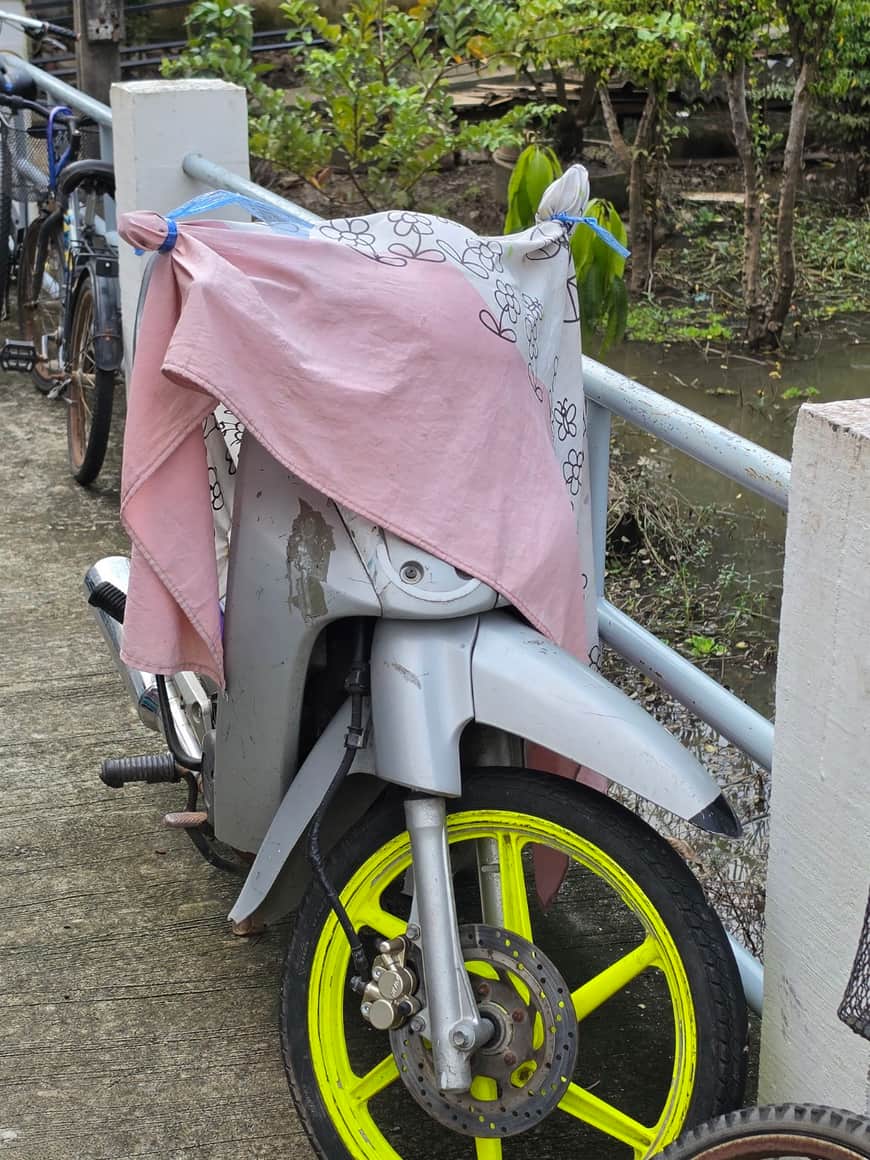 Scooter partiellement recouvert d’un tissu rose.