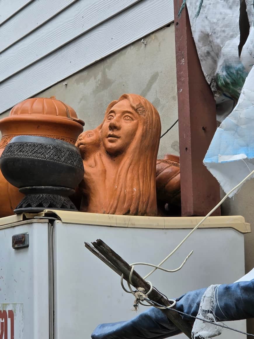 Têtes sculptées et objets disposés sur une étagère.