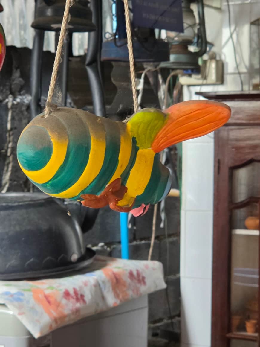 Objet décoratif suspendu en forme de poisson coloré.