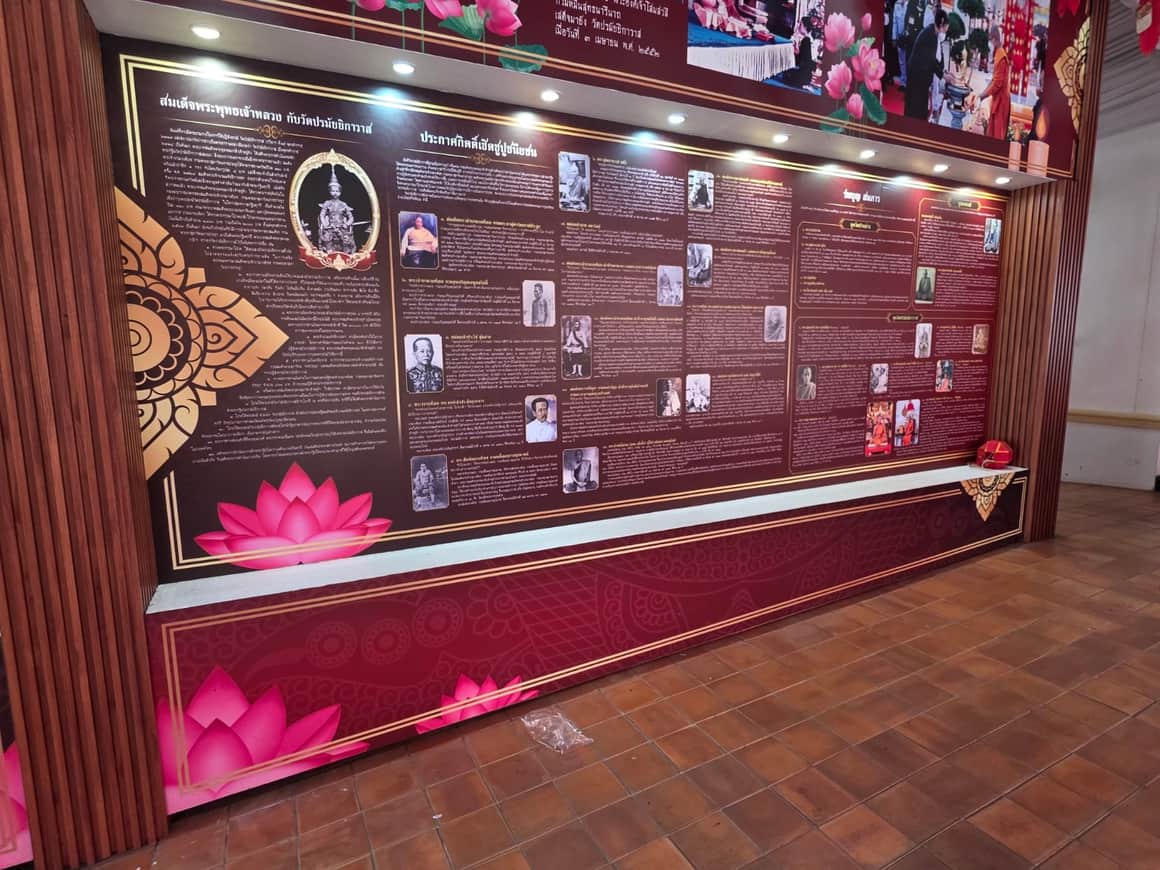 Vitrine d’exposition avec des documents et objets sur fond rouge sombre.