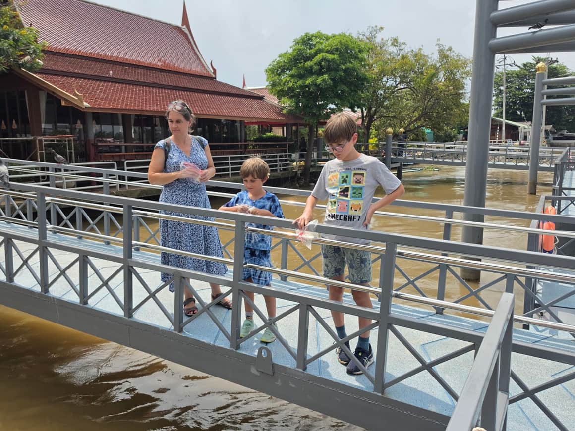 Plusieurs personnes, dont un enfant, sur une passerelle au-dessus de l’eau.