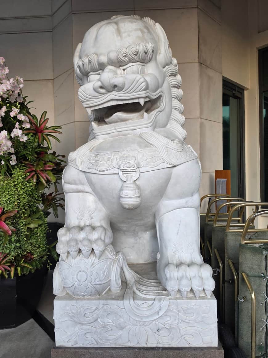 Sculpture de lion assis à l’entrée d’un bâtiment.