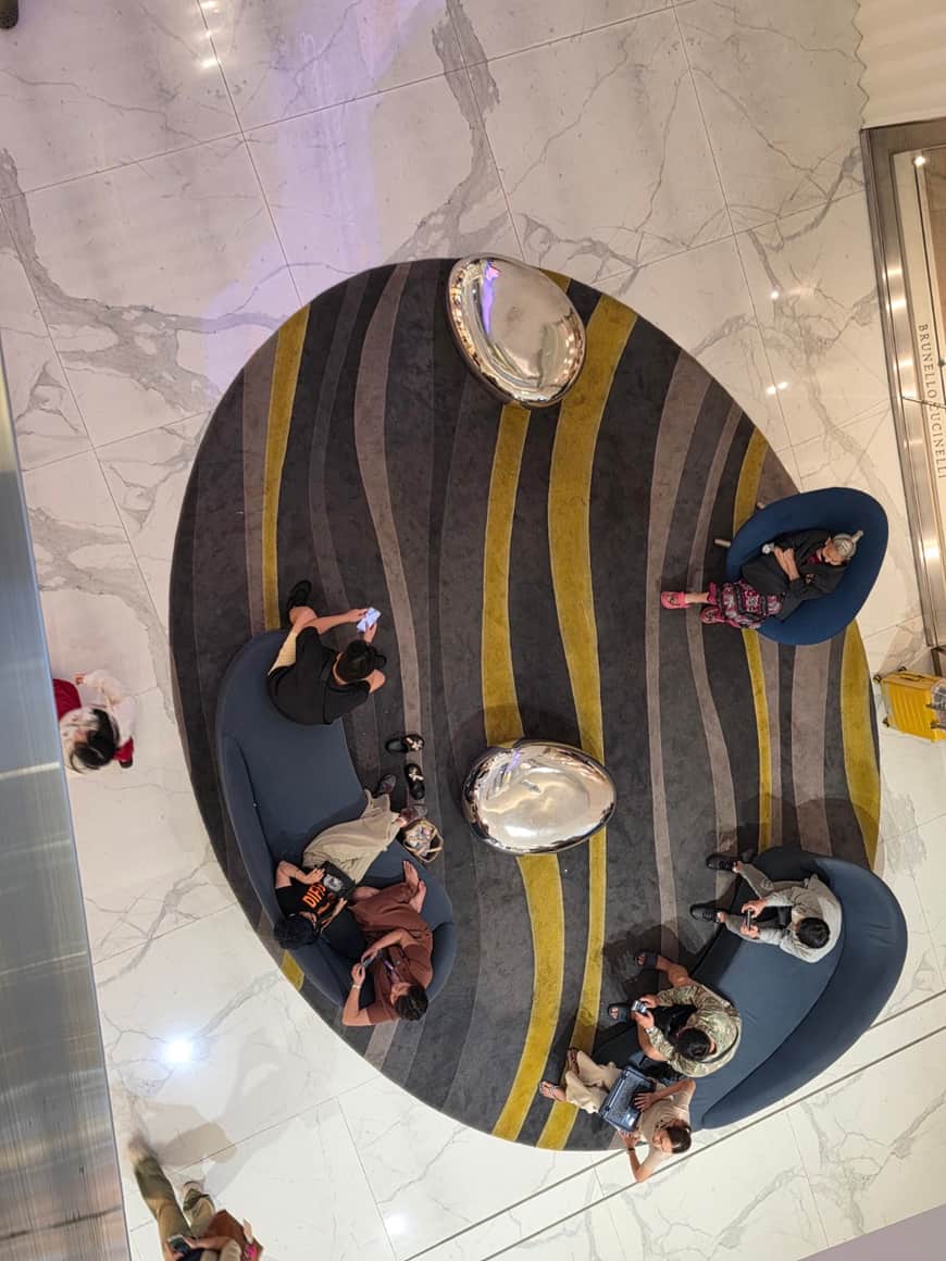 Vue en plongée d’un atrium circulaire et des visiteurs en contrebas.