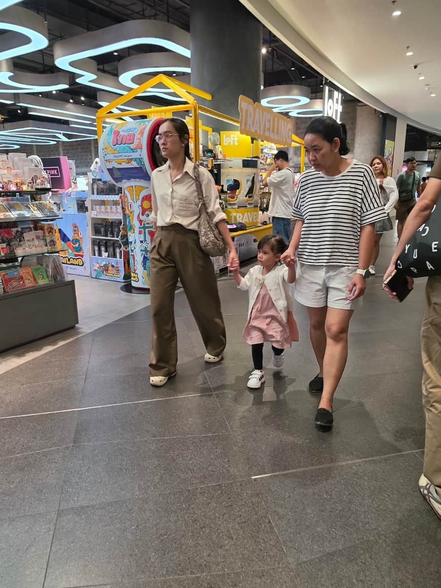 Plusieurs visiteurs, dont un enfant, dans une galerie commerciale.