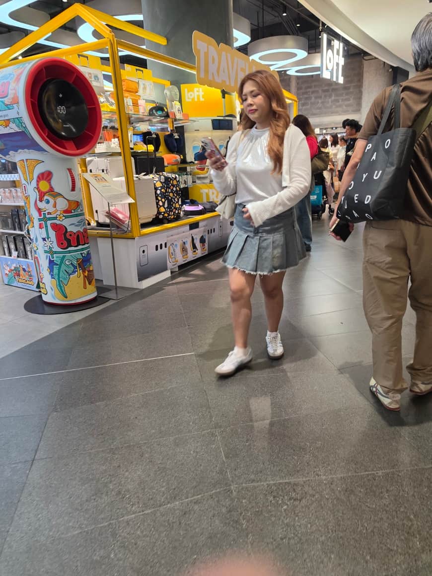 Passante devant un kiosque décoré dans une galerie.