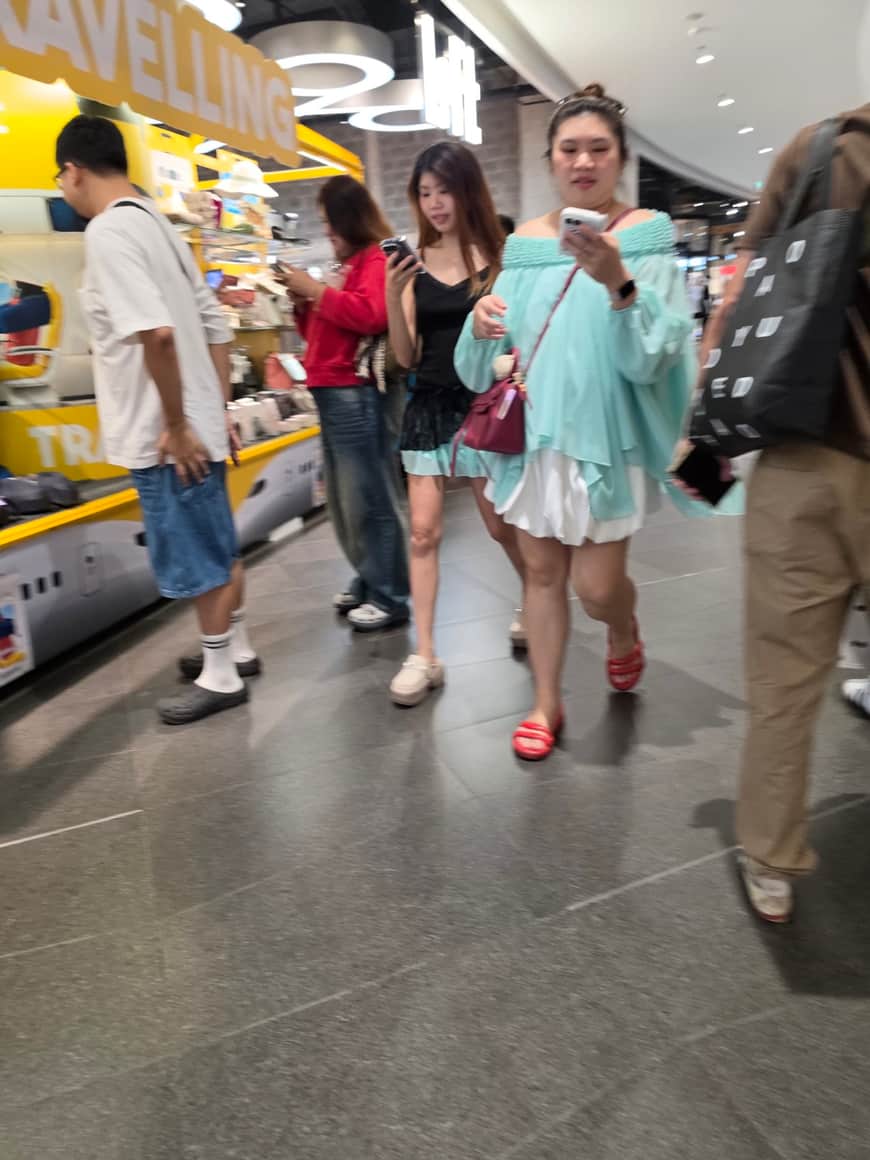 Visiteurs avançant dans une allée commerciale éclairée.