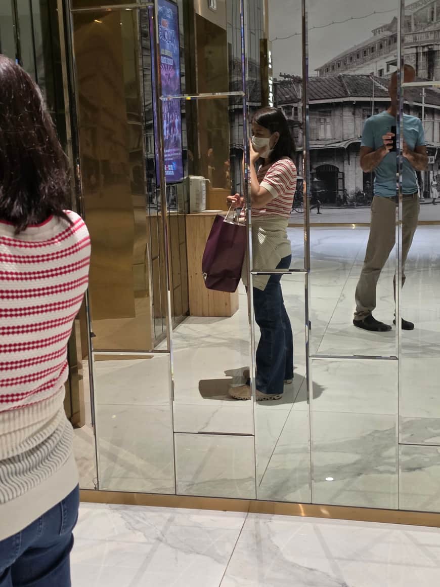 Passante et reflets dans une vitrine.
