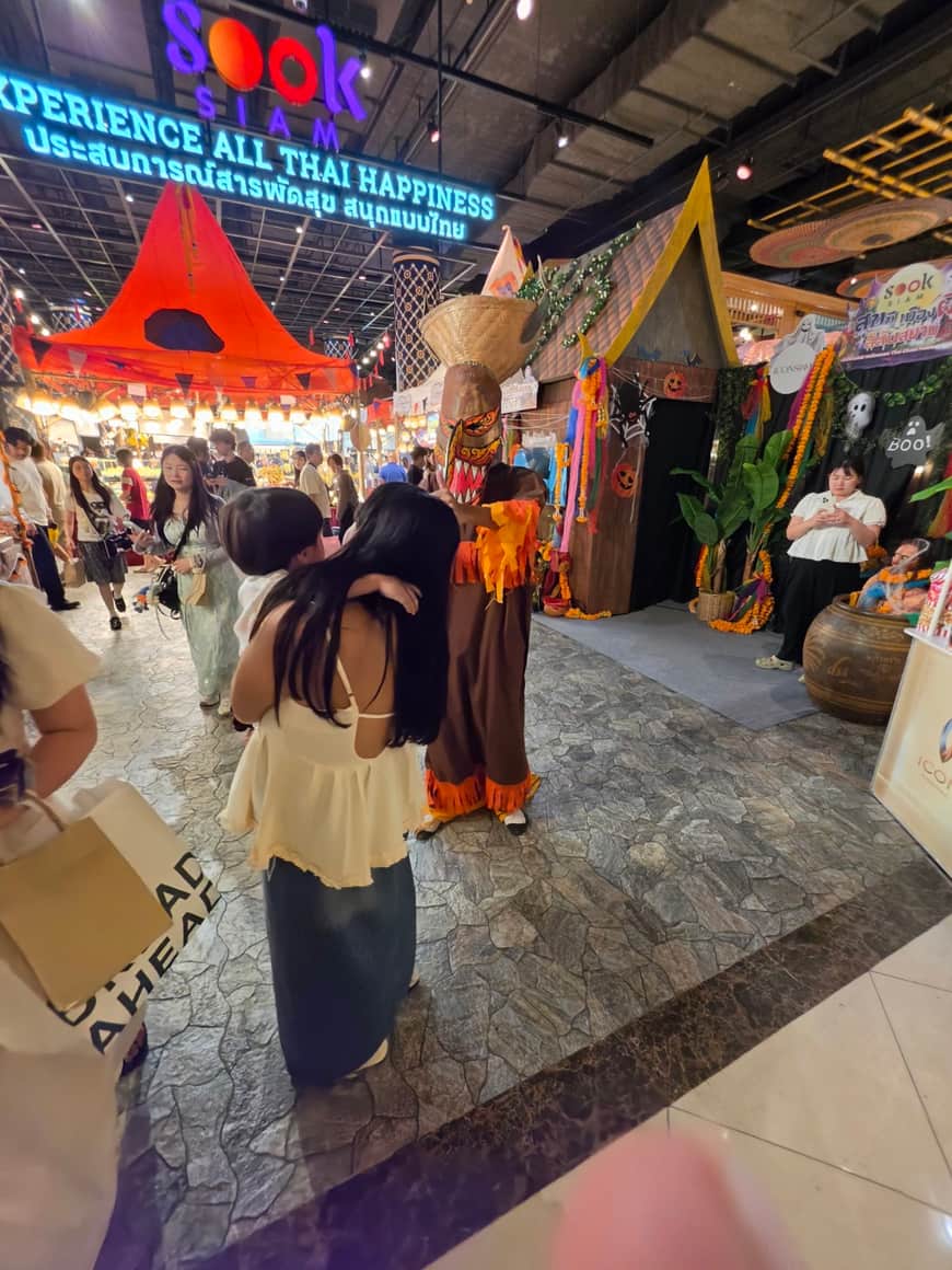 Allée d’un espace commercial animé, entre stands et visiteurs.