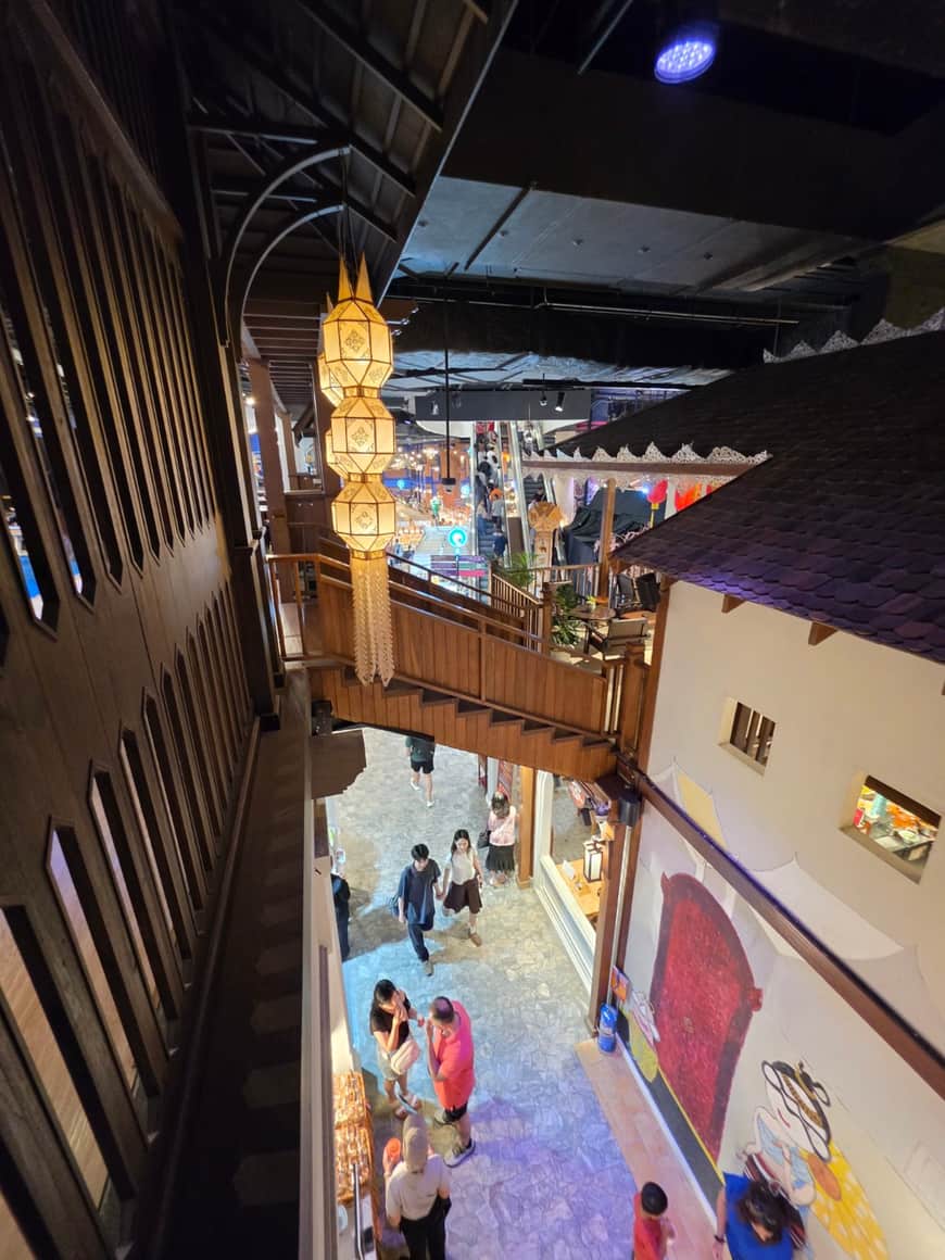 Vue plongeante sur un escalator et les étages d’un espace commercial.