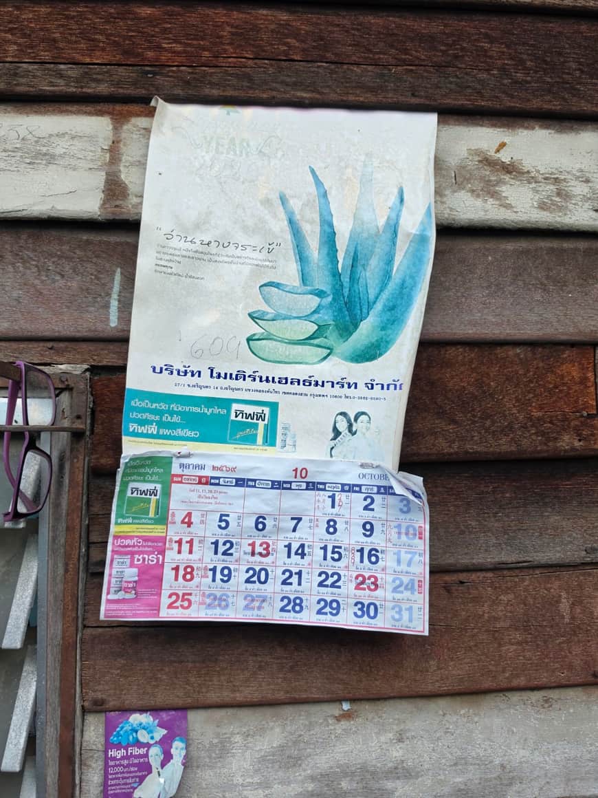 Calendrier illustré accroché à une paroi de bois.