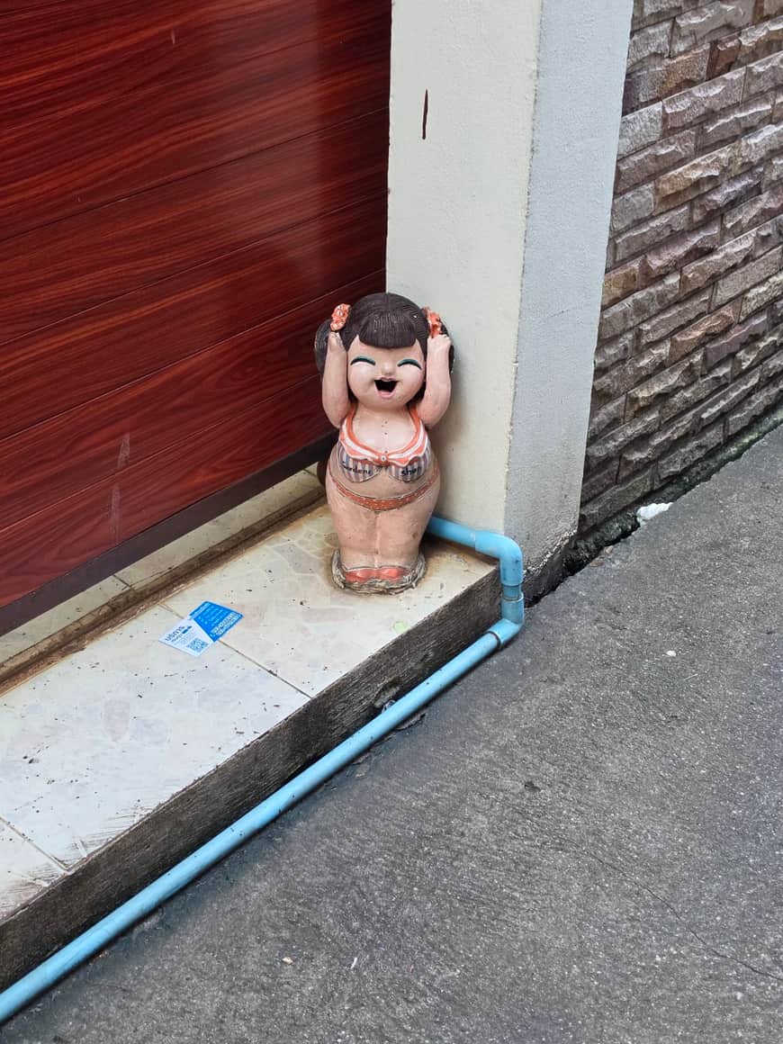 Petite figurine en terre cuite au seuil d’une porte.