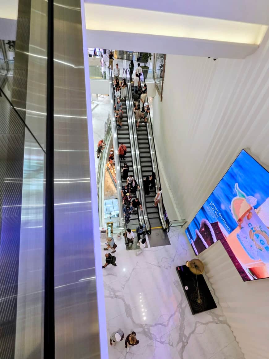 Escalators et étages d’une galerie commerciale vus en plongée.