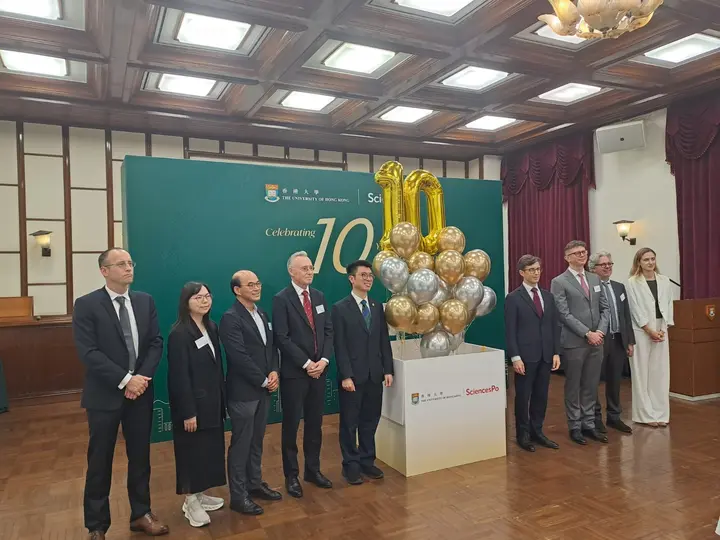 Groupe réuni devant un fond de l’Université de Hong Kong et de Sciences Po, auprès de ballons formant le nombre dix