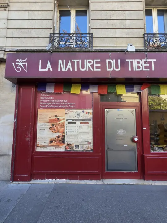 Façade rouge d’un commerce portant en grandes lettres l’enseigne La Nature du Tibet