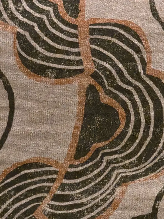 Très gros plan d’un textile orné de courbes noires, crème et brunes