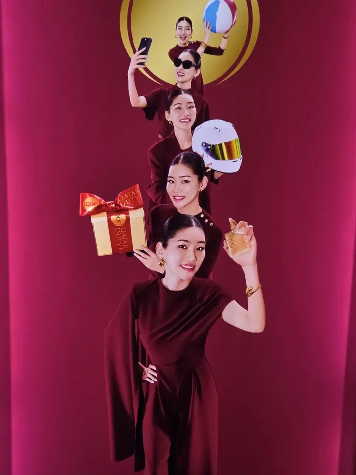 Affiche Qatar Duty Free où cinq figures féminines présentent ballon, téléphone, casque, cadeau et parfum.