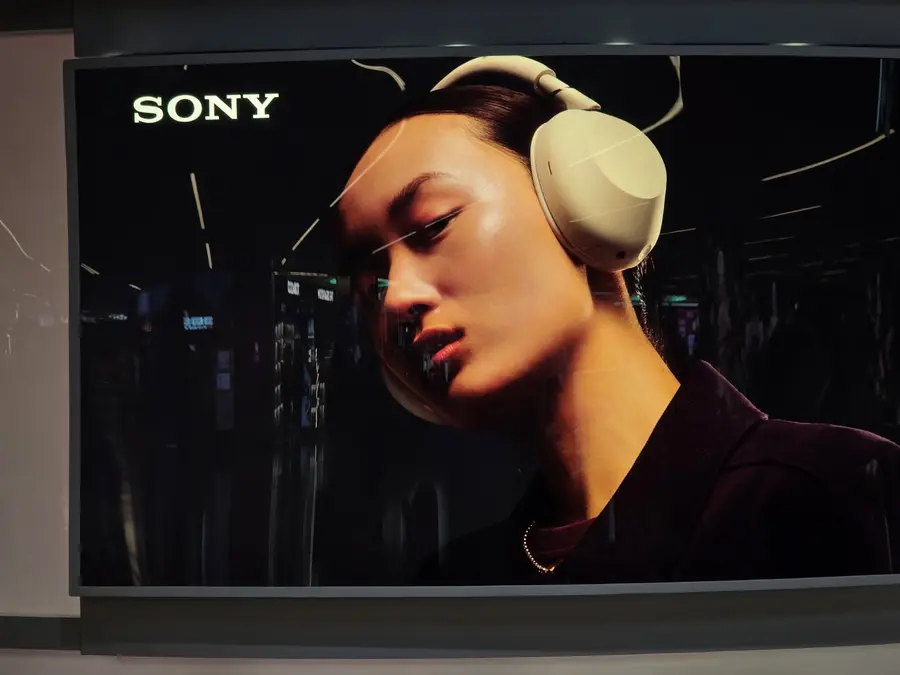 Publicité Sony montrant une femme portant un casque audio, les paupières baissées.