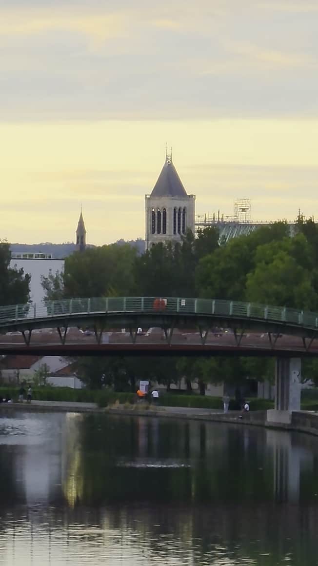 Canal calme, passerelle, clocher et ciel du soir
