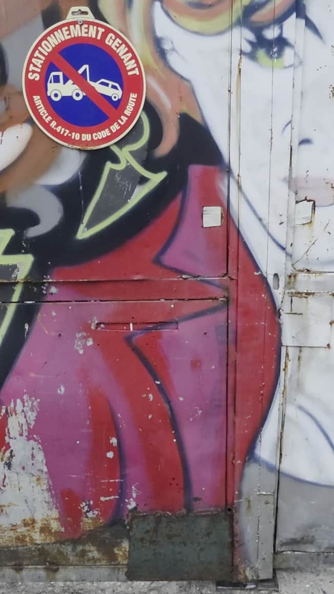 Mur peint, panneau circulaire et petite plaque claire